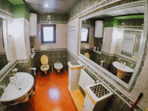 a bathroom with two toilets and a sink and a mirror at DB Apartment in Tirana