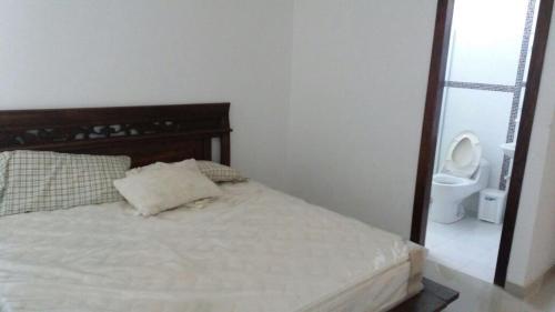 a bedroom with a bed and a toilet in a room at Cabaña Villa Flower Gold in Juan de Acosta