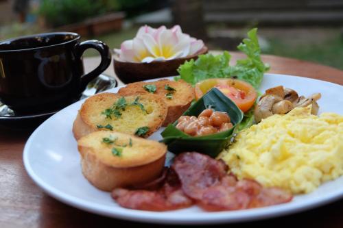 a plate of breakfast food on a wooden table at D'Pande Kuta in Kuta