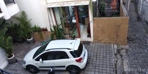 a white car parked in front of a building at D'Pande Kuta in Kuta
