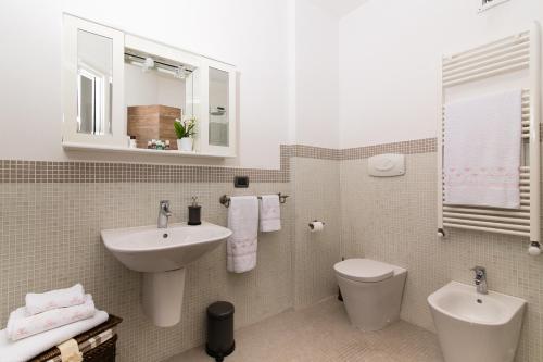 bagno con lavandino, servizi igienici e specchio di Lovely Apartment between Sea and Mountains a Querceta