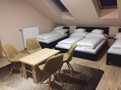 サルバシュにあるMOKKA PANZIÓのベッドが3つとテーブルと椅子がある部屋
