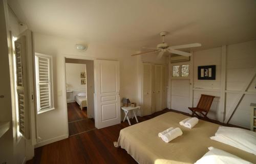 a bedroom with a bed and a ceiling fan at La Villa du soleil in Les Trois-Îlets