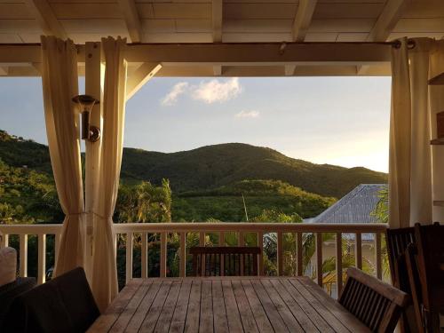 a porch with a view of a mountain at La Villa du soleil in Les Trois-Îlets