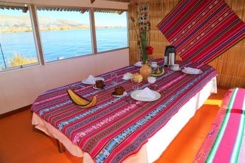 un tavolo con piatti e banane sopra di Titicaca Sariri Lodge a Puno