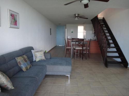 a living room with a couch and a dining room at Sunset Paradise - Ocean View Penthouse Apartment in Cabo Rojo