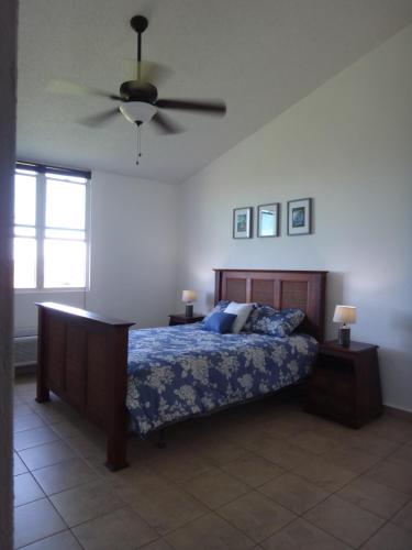 a bedroom with a bed and a ceiling fan at Sunset Paradise - Ocean View Penthouse Apartment in Cabo Rojo