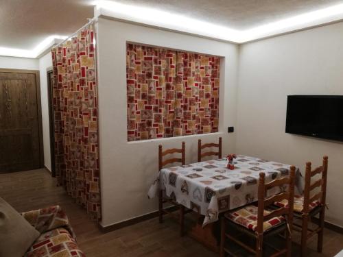 una sala da pranzo con tavolo, sedie e una finestra di Cervinia Ski In Ski Out - Studio on the slopes a Breuil-Cervinia