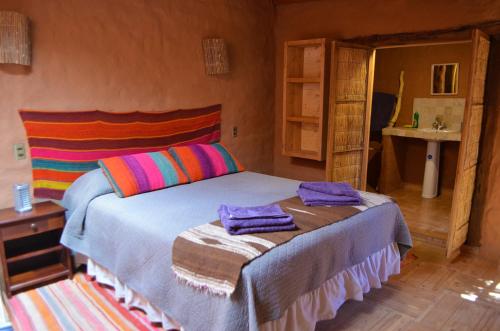 a bedroom with a bed with towels on it at Ckuri Atacama in San Pedro de Atacama