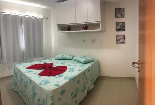 a small bedroom with a bed with a blue and red sheets at Vog Torres do Sul in Ilhéus