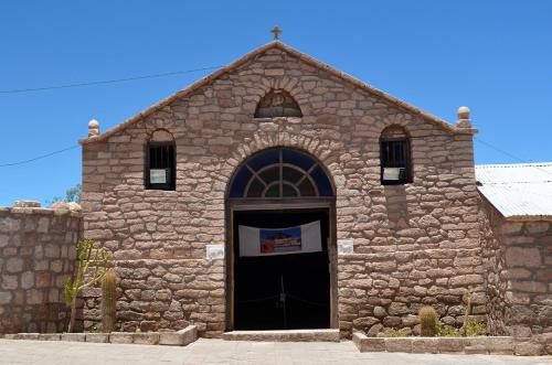 an old stone church with a black door at Ckuri Atacama in San Pedro de Atacama