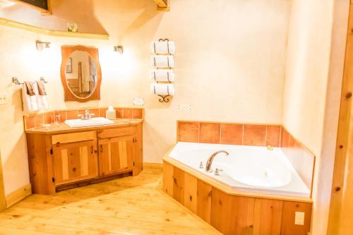 a bathroom with a large tub and a sink at Riverside Cottage #26 in Ruidoso