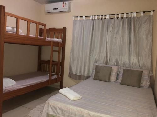 a bedroom with two bunk beds and a window at Casa de Férias em Alter do Chão-PA in Alter do Chao