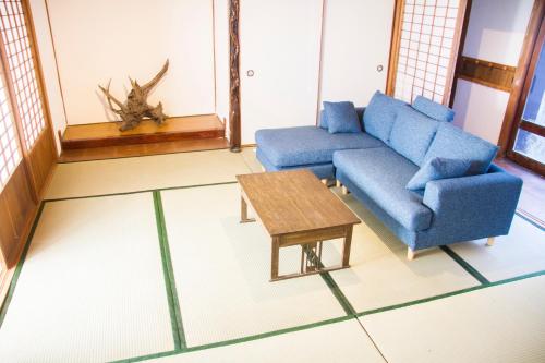 a living room with a blue couch and a coffee table at Engawa in Tonosho