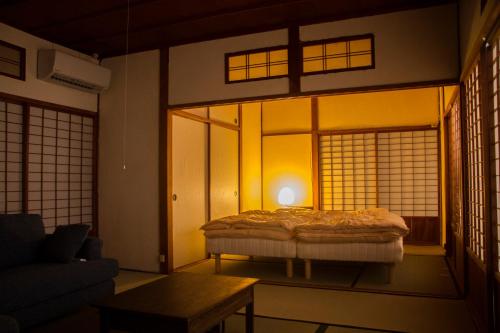 - une chambre avec un lit dans une pièce dotée de fenêtres dans l'établissement Engawa, à Tonosho