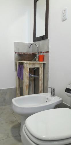 a bathroom with a white toilet and a sink at Aluminé in Colón