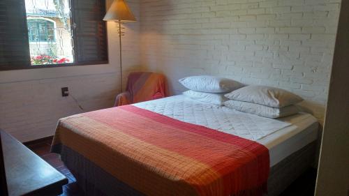 a bedroom with a bed with a colorful blanket at Chácara Picumã in São Francisco Xavier