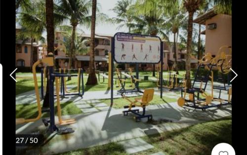 a playground with chairs and a sign in a park at Genipabu Summer House Guarajuba in Guarajuba