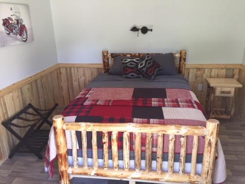 a bedroom with a wooden bed with a blanket at Eycat Lodging Company in Wapiti