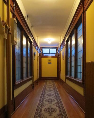 an empty hallway with windows and a rug at Arundel Mansions Hotel in New Westminster