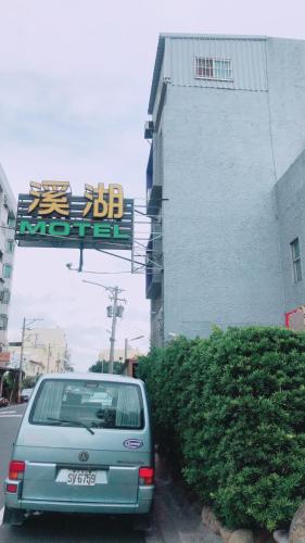 a car parked in front of a building with a sign at 溪湖汽車旅館 in Xihu