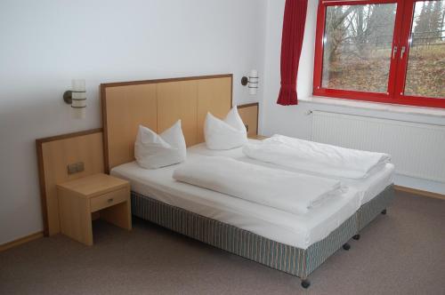 a bedroom with a bed with white sheets and a window at Kegel Tanz Palast Winterberg in Winterberg