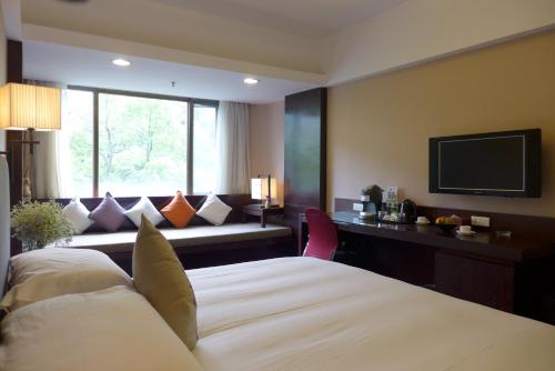 a hotel room with a bed and a television at SSAW Boutique Hotel Hangzhou Yilian in Hangzhou