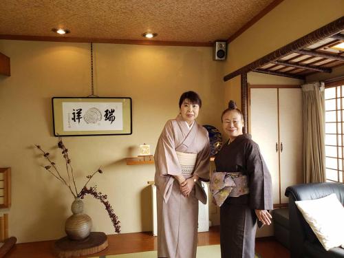 a man and a woman standing in a room at Shiroyama Ryokan in Ikuma
