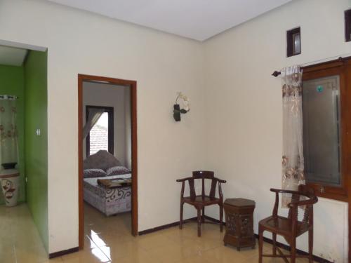 a room with two chairs and a room with a bed at Villa Anna in Bromo