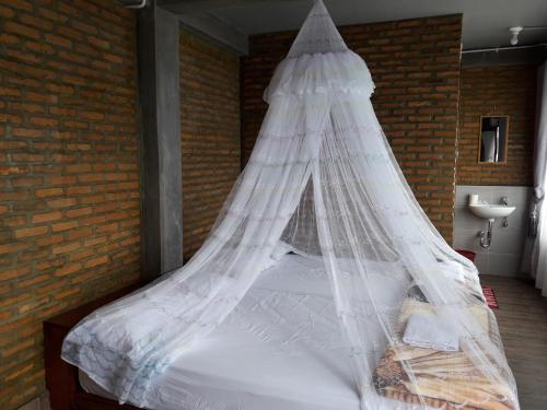 a bed with a mosquito net on top of it at Pondok Berata Dapdap in Balige