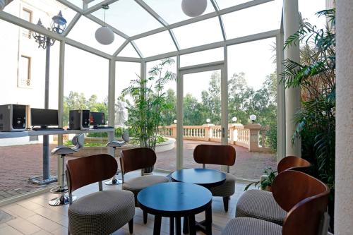 a room with chairs and tables and a large window at Golden Tulip - Aesthetics in Zhunan