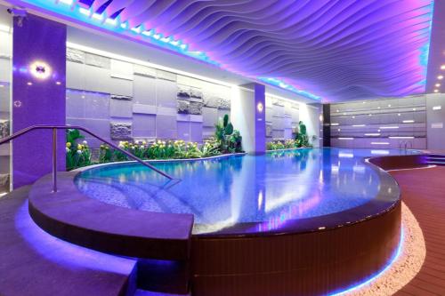 a large swimming pool in a building with purple lighting at Golden Tulip - Aesthetics in Zhunan