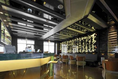 a restaurant with a bar with chairs and tables at Golden Tulip - Aesthetics in Zhunan