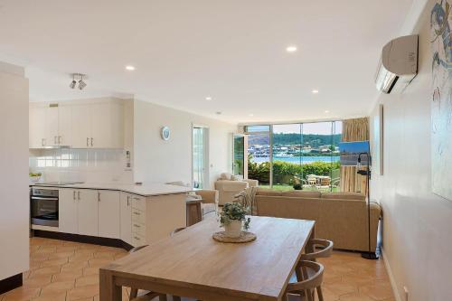 a kitchen and living room with a table and a dining room at Cetacea Luxury Apartments in Merimbula