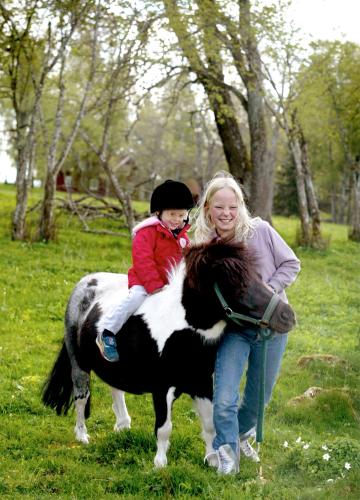 a woman holding a child sitting on top of a pony at Kullagården in Vreta Kloster