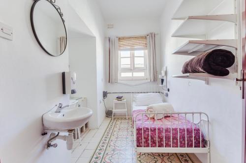 a small white bathroom with a sink and a sink at Granny's Inn Hostel in Sliema