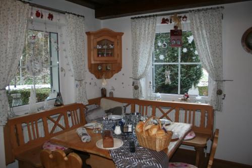 een eetkamer met een tafel en een aantal ramen bij Haus Emily in Schladming