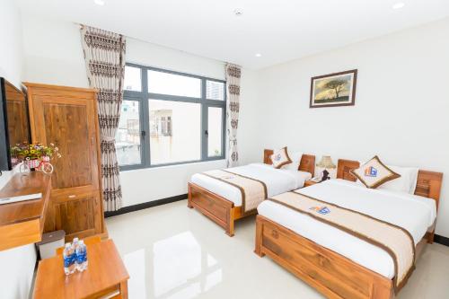 a hotel room with two beds and a window at HUNG GIA HOTEL in Quy Nhon