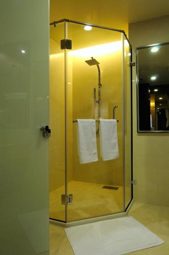 a glass shower stall with towels in a bathroom at Hai Yue Hotel in Magong