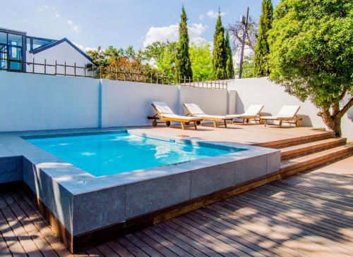 a swimming pool with two lounge chairs and a patio at Blix in Stellenbosch