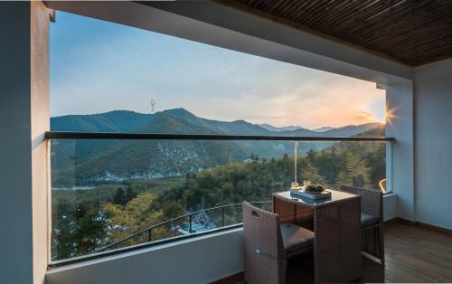 a room with a large window with a mountain view at The Western Clouds in Deqing