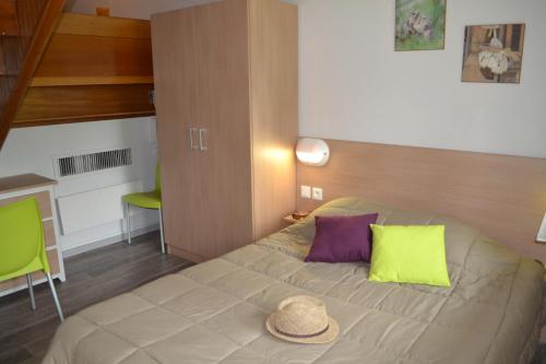 a bedroom with a bed with a hat on it at VVF Les Ecrins Champsaur in Saint-Bonnet-en-Champsaur