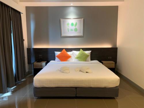 a bedroom with a bed with colorful pillows at Clover Hotel Hatyai in Hat Yai