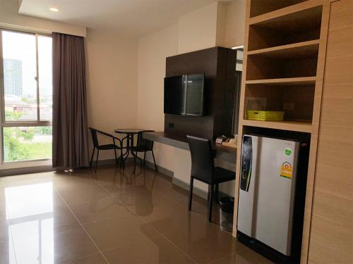 a room with a kitchen with a table and a refrigerator at Clover Hotel Hatyai in Hat Yai
