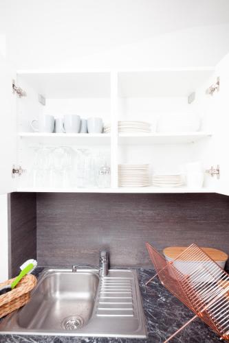 a kitchen counter with a sink and white cabinets at Apartment Bergkristall in Sonnenalpe Nassfeld
