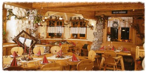 uma sala de jantar com mesas e cadeiras de madeira e janelas em Appartement Klapotetz em Bad Gastein