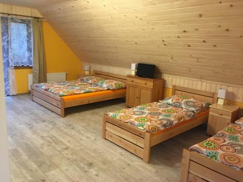 a room with three beds and a tv in it at Privat 66 in Liptovský Trnovec