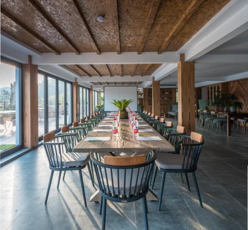 a long dining room with a long table and chairs at The Western Clouds in Deqing
