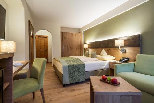 ヒパッハにあるFerienhotel Neuwirtのベッド1台と椅子2脚が備わるホテルルームです。