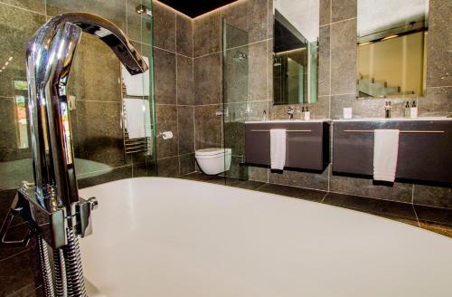 een badkamer met een bad en 2 wastafels bij De Haas Living @ Die Laan 2 in Stellenbosch